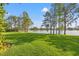 Expansive backyard featuring a tranquil lake view and lush green lawn and trees at 4121 Highland Park Cir, Lutz, FL 33558