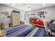 Comfortable bedroom with colorful decor, featuring a ceiling fan and a large striped rug at 4121 Highland Park Cir, Lutz, FL 33558