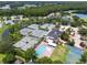 Aerial view of community tennis courts and a sparkling pool in a lush, green setting at 4121 Highland Park Cir, Lutz, FL 33558