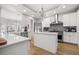 Modern kitchen features white cabinets, stainless steel appliances, a center island, and hardwood flooring at 4121 Highland Park Cir, Lutz, FL 33558