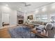 Cozy living room featuring a stone fireplace, hardwood floors, and a comfortable sectional sofa at 4121 Highland Park Cir, Lutz, FL 33558