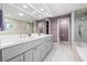 Beautiful main bathroom featuring double sinks, a large mirror, and a glass-enclosed shower at 4121 Highland Park Cir, Lutz, FL 33558