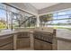 Built-in outdoor kitchen featuring a grill, cooktop, and fridge, perfect for entertaining at 4121 Highland Park Cir, Lutz, FL 33558