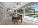 Covered patio with outdoor dining, bar, and serene view of the pool and lake at 4121 Highland Park Cir, Lutz, FL 33558