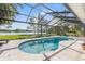 Screened-in pool area with lounge chairs, a lake view, and lush landscaping at 4121 Highland Park Cir, Lutz, FL 33558