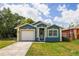 Charming single-Gathering home featuring blue and beige exterior with a well-maintained lawn and attached garage at 4610 Courtland St, Tampa, FL 33610
