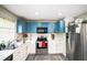 Updated kitchen with modern stainless steel appliances, white countertops, and stylish blue upper cabinets at 4610 Courtland St, Tampa, FL 33610