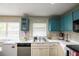 Bright kitchen with white cabinets, stainless steel appliances, and contrasting blue upper cabinets at 4610 Courtland St, Tampa, FL 33610