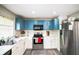 Updated kitchen with modern stainless steel appliances, white countertops, and stylish blue upper cabinets at 4610 Courtland St, Tampa, FL 33610