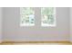 Bedroom featuring light hardwood floors, white walls, and two windows at 5051 Gevalia Dr, Brooksville, FL 34604