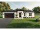 Charming single-story home featuring a manicured lawn and a modern two-car garage at 5051 Gevalia Dr, Brooksville, FL 34604
