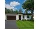 Charming one-story home with a two-car garage, manicured lawn, and welcoming front entrance at 5051 Gevalia Dr, Brooksville, FL 34604