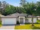 Charming single-story home with a well-manicured lawn, modern white exterior, and inviting entryway at 5051 Gevalia Dr, Brooksville, FL 34604