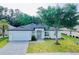 Charming single-story home featuring a paved driveway, well-manicured lawn, and stylish modern design at 5051 Gevalia Dr, Brooksville, FL 34604
