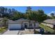 Charming single-story home with a two-car garage, gray roof, and landscaped yard at 5051 Gevalia Dr, Brooksville, FL 34604