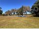 Golf course view with large trees and a serene lake, providing a picturesque setting for golfers at 5051 Gevalia Dr, Brooksville, FL 34604