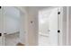 Hallway view showcasing white doors, a bathroom, and an adjacent bedroom with hardwood floors at 5051 Gevalia Dr, Brooksville, FL 34604