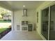 This covered patio includes an outdoor kitchen with a grill, fridge, and views of the green yard at 5051 Gevalia Dr, Brooksville, FL 34604