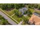 Aerial view of a blue house with a gray roof, large lawn, screened pool, and lush trees at 5913 Flatwoods Manor Cir, Lithia, FL 33547