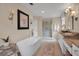 Bright bathroom with a freestanding tub, glass shower, and double sink vanity with granite countertops at 5913 Flatwoods Manor Cir, Lithia, FL 33547