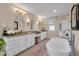 Bright bathroom featuring a freestanding tub and double sink vanity with granite countertops at 5913 Flatwoods Manor Cir, Lithia, FL 33547