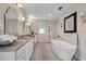 Bright bathroom with granite countertops, double sink vanity, and decorative lighting at 5913 Flatwoods Manor Cir, Lithia, FL 33547