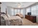Bright bedroom with a ceiling fan, large windows, and a cozy seating area at 5913 Flatwoods Manor Cir, Lithia, FL 33547