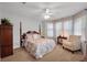 Bright bedroom with a four-poster bed, plush carpeting, and large windows with sheer curtains at 5913 Flatwoods Manor Cir, Lithia, FL 33547