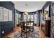 Formal dining room with rich wood floors, ornate chandelier, and large windows with patterned curtains at 5913 Flatwoods Manor Cir, Lithia, FL 33547