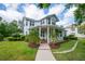 Beautiful two-story home with a welcoming front porch, lush lawn, and manicured landscaping at 5913 Flatwoods Manor Cir, Lithia, FL 33547