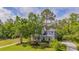 Charming two-story home with a landscaped yard, mature trees, and a inviting front porch at 5913 Flatwoods Manor Cir, Lithia, FL 33547