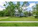 Beautiful two-story home with manicured lawn, sidewalk, mature trees, and a welcoming front porch at 5913 Flatwoods Manor Cir, Lithia, FL 33547