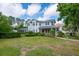 Charming two-story home with large front yard, welcoming front porch, screened in pool, and beautiful curb appeal at 5913 Flatwoods Manor Cir, Lithia, FL 33547