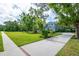 View of the side of a charming blue two-story home with well-manicured lawns and a long driveway at 5913 Flatwoods Manor Cir, Lithia, FL 33547