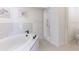 Bright bathroom featuring a tub, tiled walls, and a frameless shower at 6208 Country Club Way, Sarasota, FL 34243
