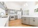 Bright kitchen featuring gray cabinets, white countertops, and stainless steel appliances at 6208 Country Club Way, Sarasota, FL 34243