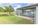 An inviting backyard features a screened lanai, lush greenery, a pond, and mature trees at 6303 Hawk Grove Ct, Wesley Chapel, FL 33545