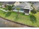 Aerial view of a backyard featuring a screened-in pool, lush green lawn, and waterfront views at 6303 Hawk Grove Ct, Wesley Chapel, FL 33545
