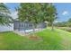 The serene backyard has a view of the pond and showcases the screened pool and lush landscaping at 6303 Hawk Grove Ct, Wesley Chapel, FL 33545