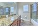 Bathroom with large granite vanity, updated fixtures, and a glass-enclosed shower at 6303 Hawk Grove Ct, Wesley Chapel, FL 33545