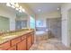 Bathroom featuring double vanity with granite counters, tiled floors, and a glass-enclosed shower at 6303 Hawk Grove Ct, Wesley Chapel, FL 33545