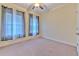 Neutral bedroom features beige walls, carpet, a ceiling fan, and natural light from two windows at 6303 Hawk Grove Ct, Wesley Chapel, FL 33545