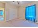 Comfortable bedroom with carpet, a double closet and window with bright blue curtains at 6303 Hawk Grove Ct, Wesley Chapel, FL 33545