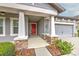 Inviting covered front porch with stone accents and a red front door enhances this home's curb appeal at 6303 Hawk Grove Ct, Wesley Chapel, FL 33545
