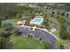Aerial view of community pool with lounge chairs, sun shelters, parking and playground at 6303 Hawk Grove Ct, Wesley Chapel, FL 33545