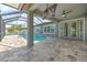 A screened lanai offers a covered outdoor seating area by the pool, with an expansive stone patio at 6303 Hawk Grove Ct, Wesley Chapel, FL 33545
