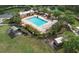 Aerial view of community pool with lounge chairs, sun shelters, parking and playground at 6303 Hawk Grove Ct, Wesley Chapel, FL 33545
