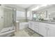 Bathroom showcasing dual sinks, granite countertops, a soaking tub, and a walk-in shower at 6518 Salt Creek Ave, Apollo Beach, FL 33572
