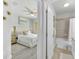 Bright bedroom and attached bathroom with a ceiling fan at 6518 Salt Creek Ave, Apollo Beach, FL 33572