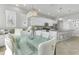 Stylish dining area with modern lighting, glass-top table, and tufted chairs, adjacent to a well-equipped kitchen at 6518 Salt Creek Ave, Apollo Beach, FL 33572